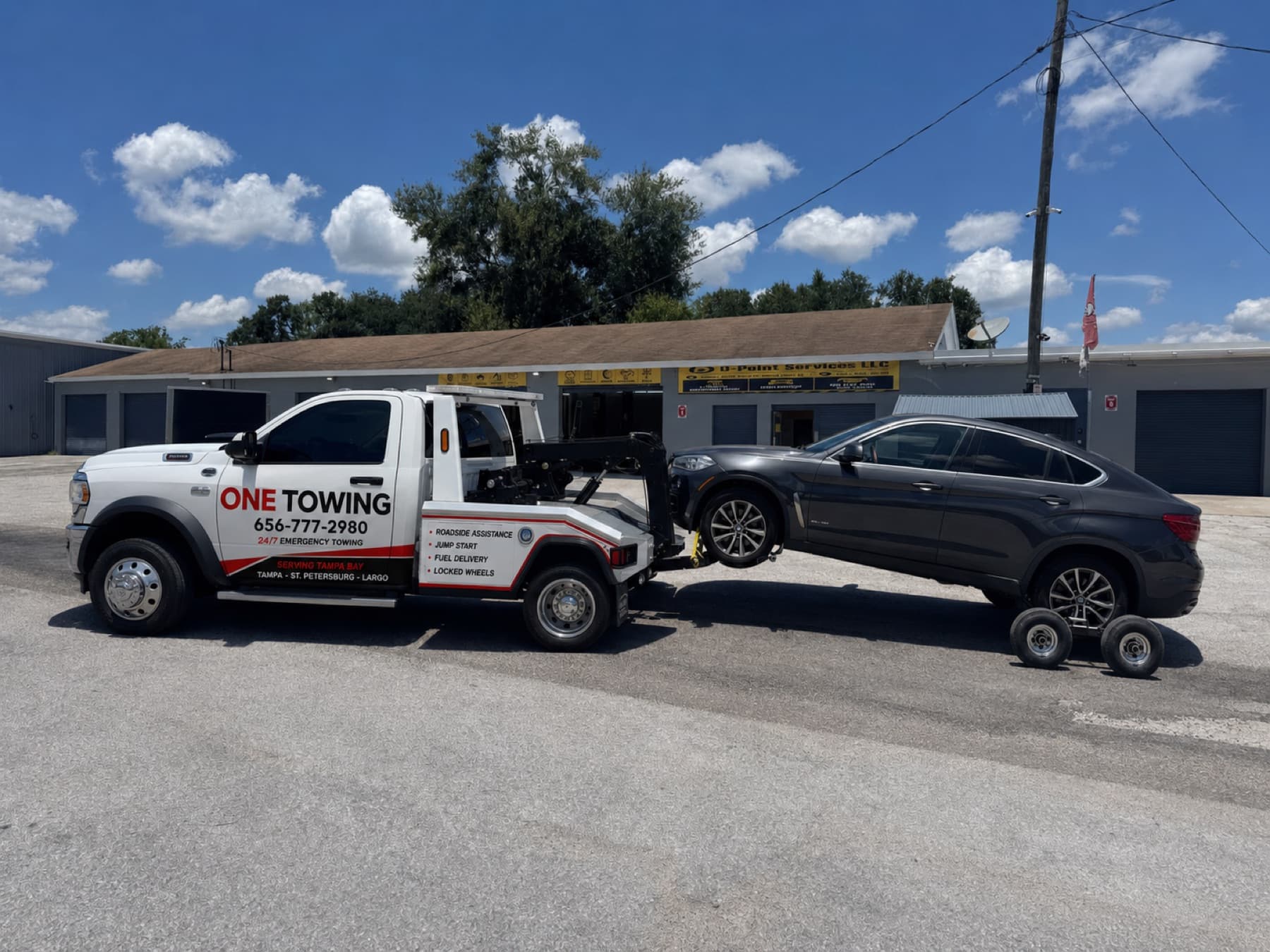 ONE TOWING wrecker towing a BMW X4 on a wheel lift with dollies in Tampa